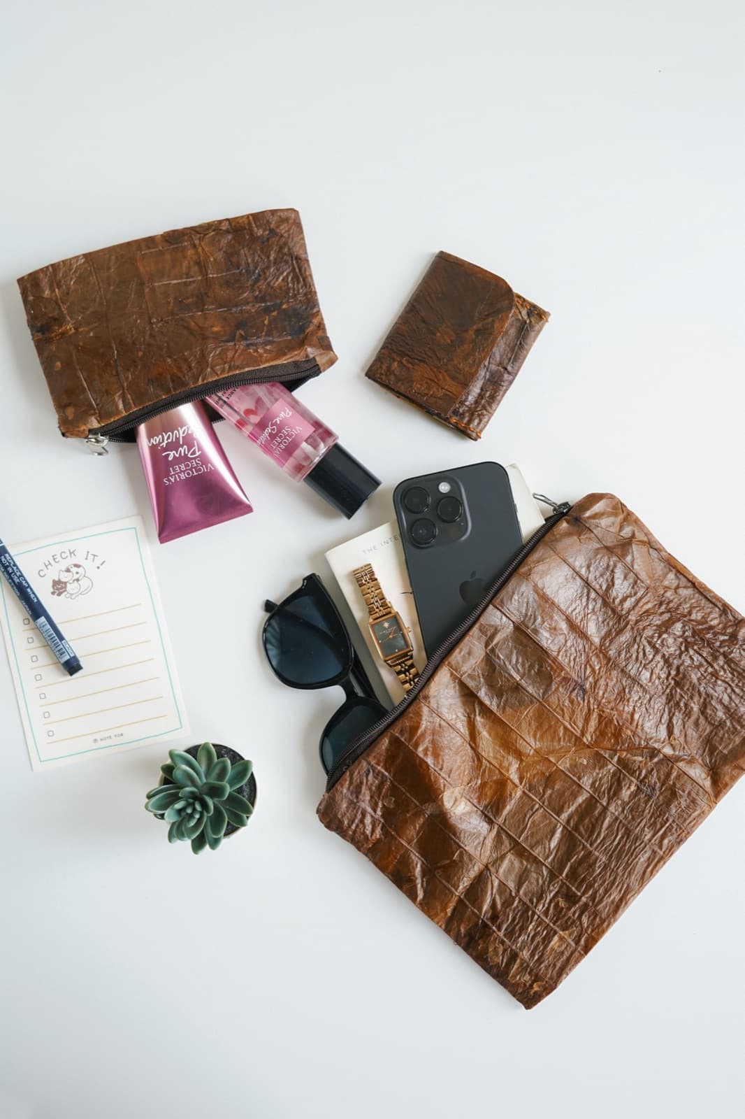 A Symbia cosmetic pouch with accessories, flat lay