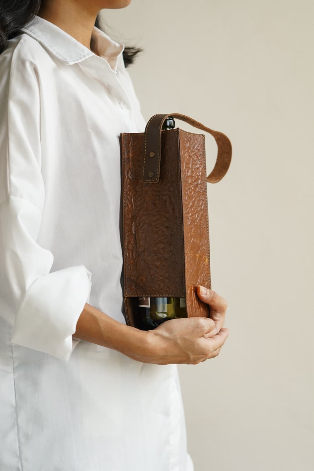 A model holding a Symbia bioleather wine holder