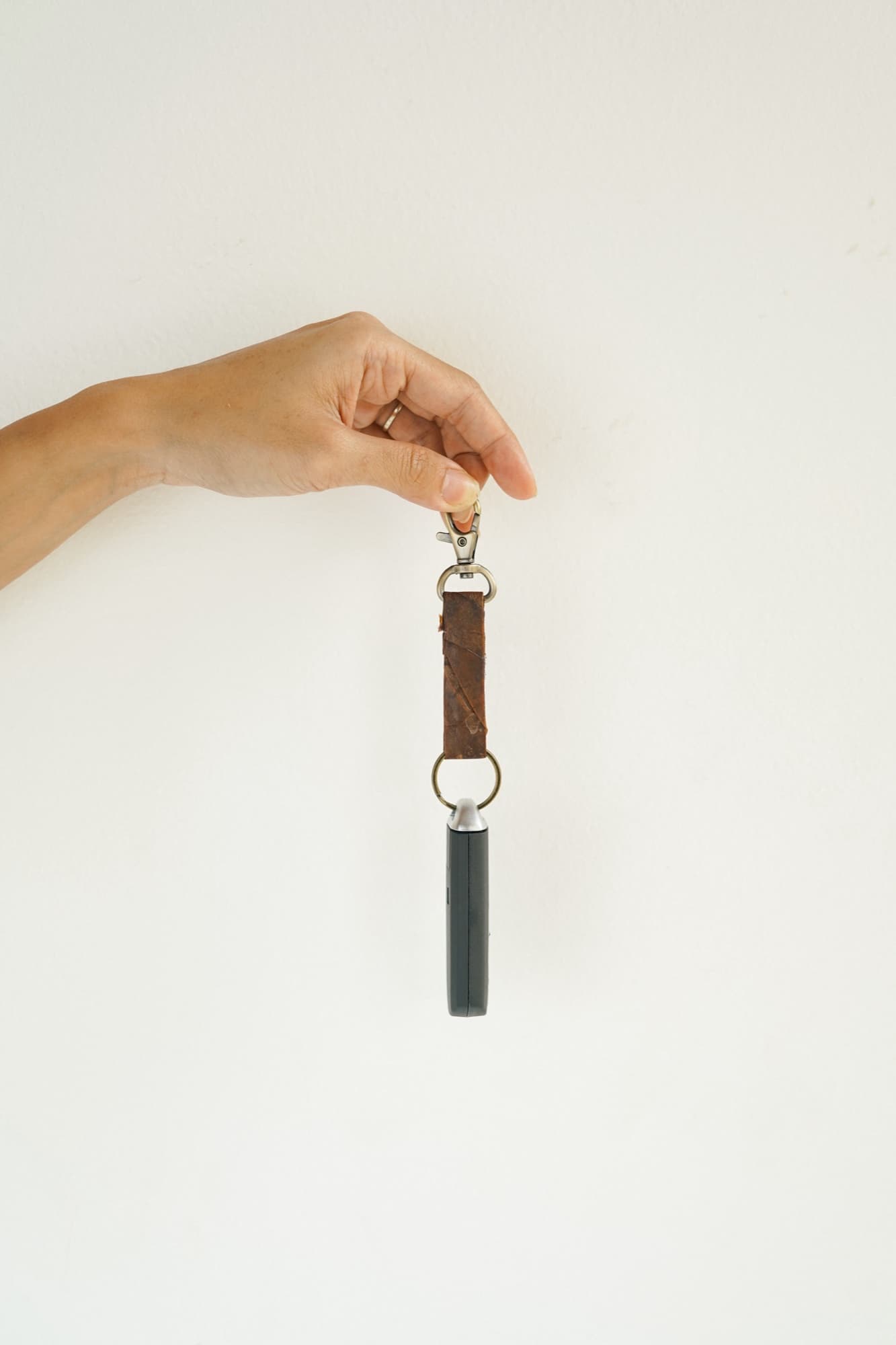 A Symbia bioleather keychain strap held up