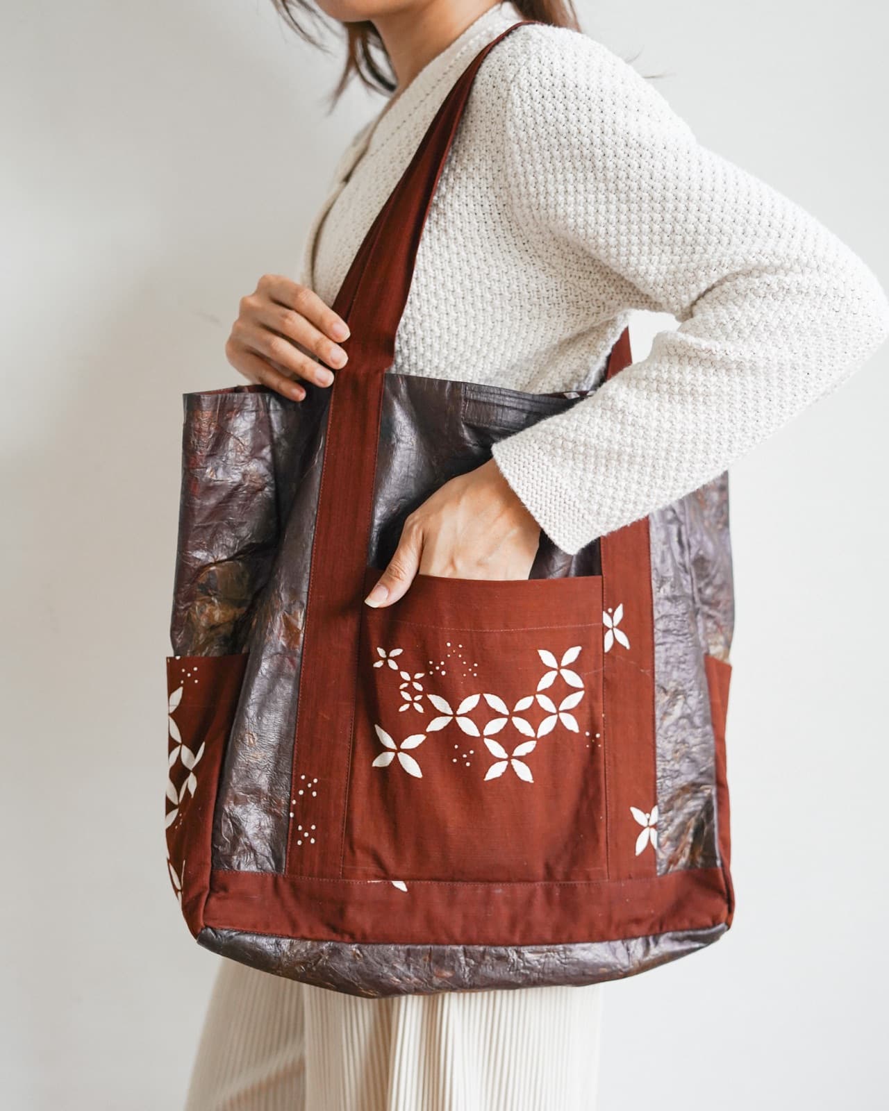 A model carrying a batik-patterned Symbia tote